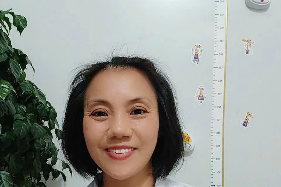 Dược sĩ Vũ Thị Tuyến đứng cạnh thước đo chiều cao